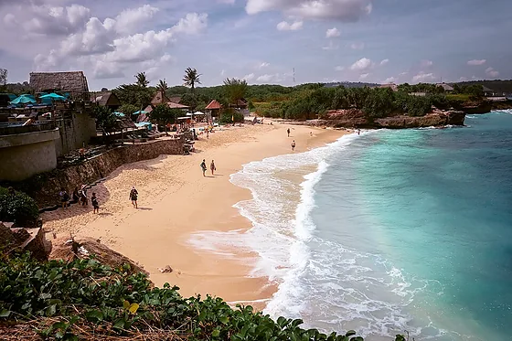 Dream Beach cove with white sand below low cliffs and turquoise water