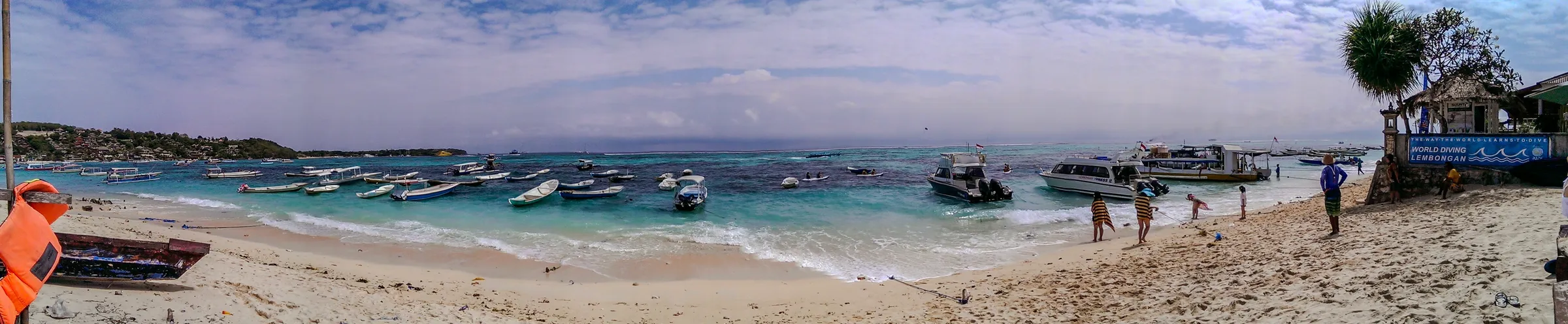 Speedboats moored off a sandy Nusa Lembongan beach with turquoise water